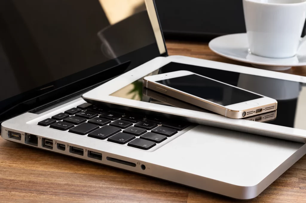 Smartphone et tablette posés sur un ordinateur portable