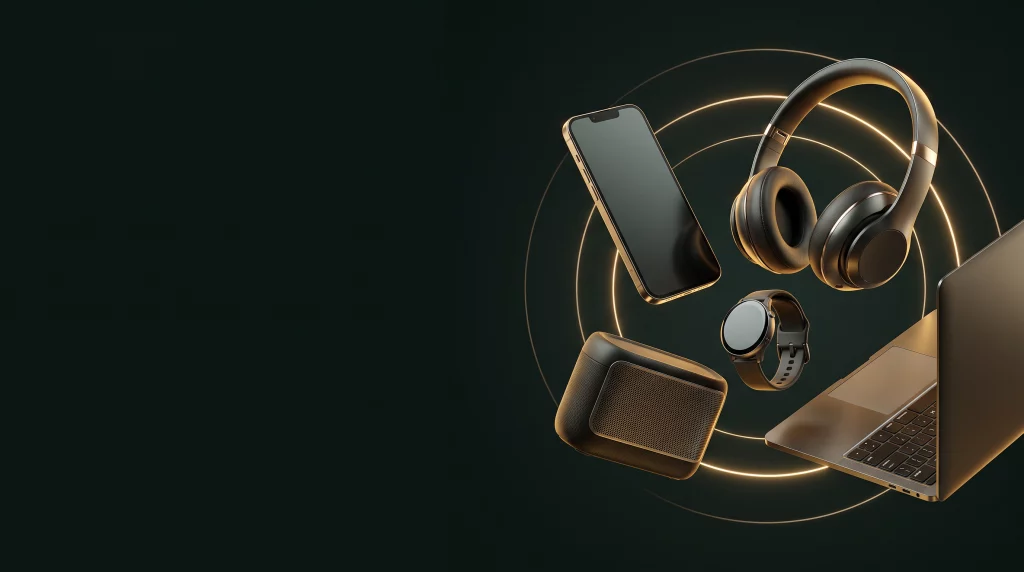 Smartphone, casque, montre, enceinte et ordinateur sur fond sombre aux reflets dorés
